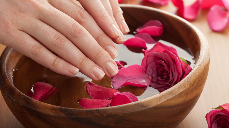 Woman soaking hands in rosewater