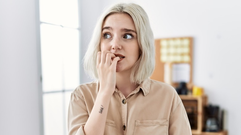 Young woman biting her nails