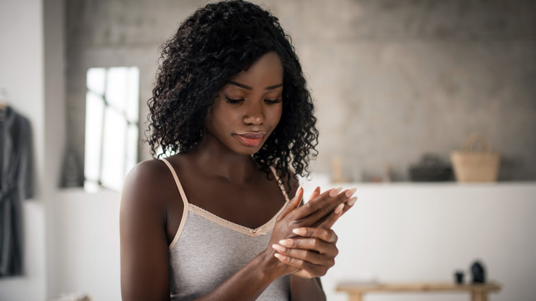 Woman applying hand lotion
