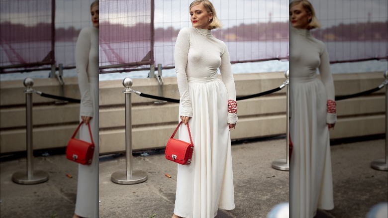 Woman wearing white, red scarf