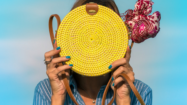 Person holding purse with scarf attached