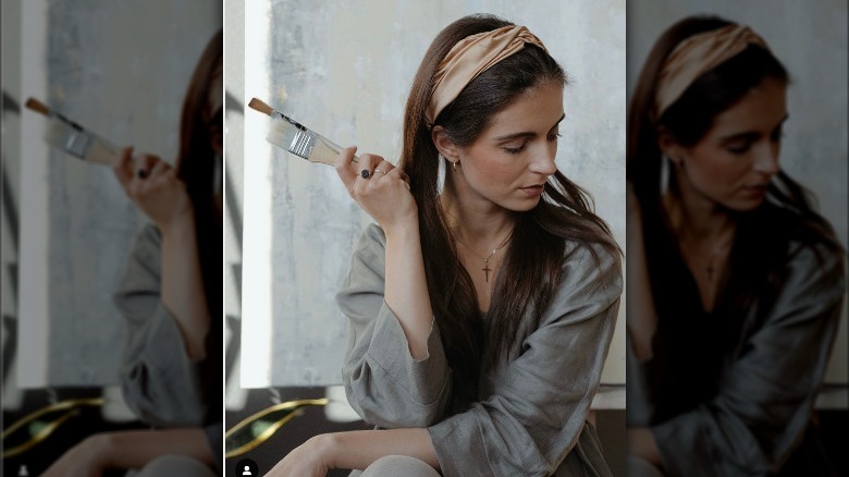Woman with headband, holding paintbrush