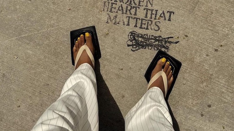Person in sandals with yellow pedicure