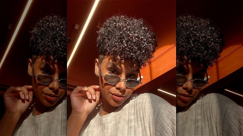 person with short curly pixie haircut