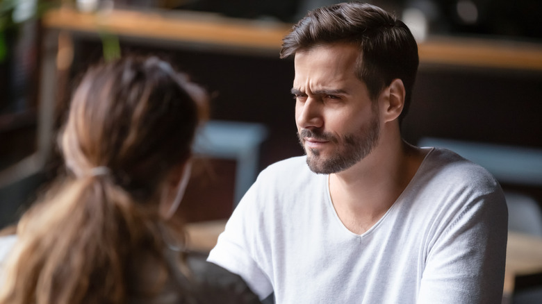 man looking at woman confused 