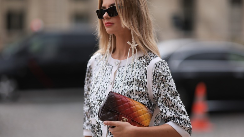 Woman carrying an ombré clutch