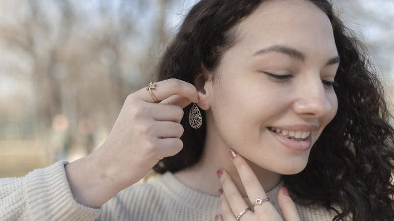 woman putting in single piercing