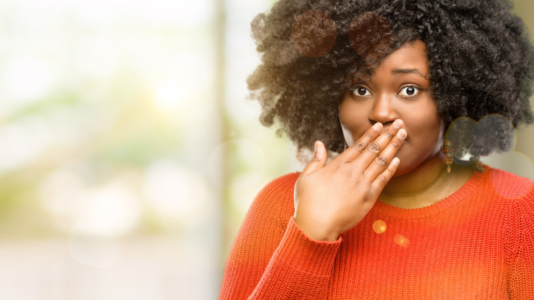 Woman putting hand over mouth