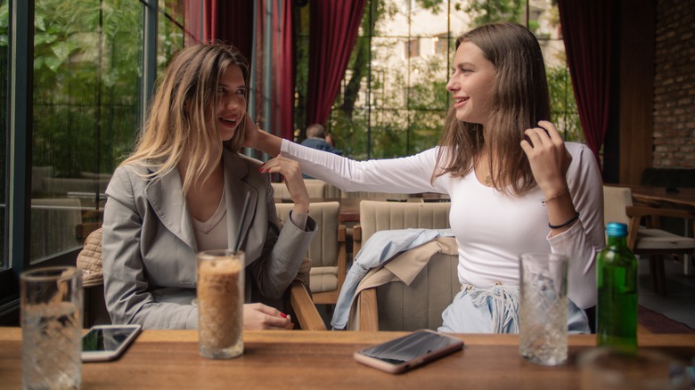 Woman complimenting friend's hair 