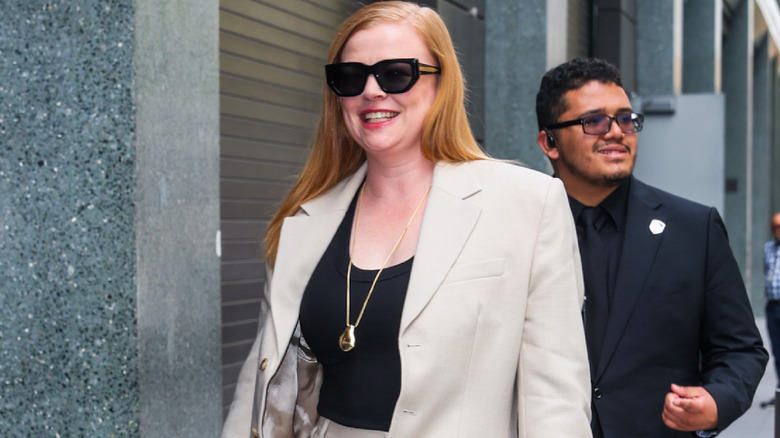 A woman wearing large sunglasses with a suit