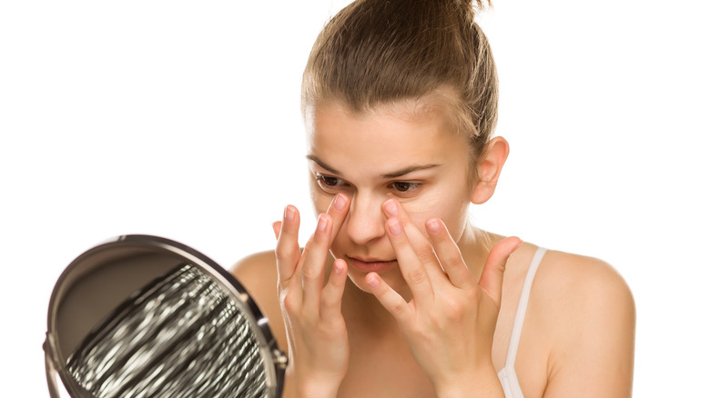 woman applying makeup under eyes