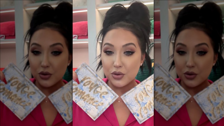 Jaclyn Hill holding up cards