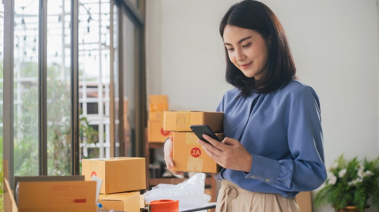 Woman on her phone holding packages