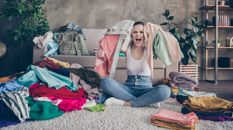 desperate woman in the middle of clothes