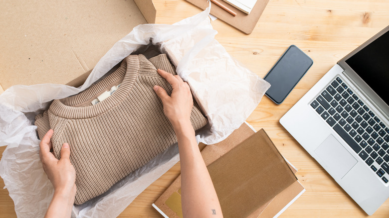 woman packing clothes in a box