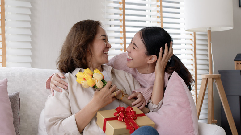 hugging friends with gift and flowers