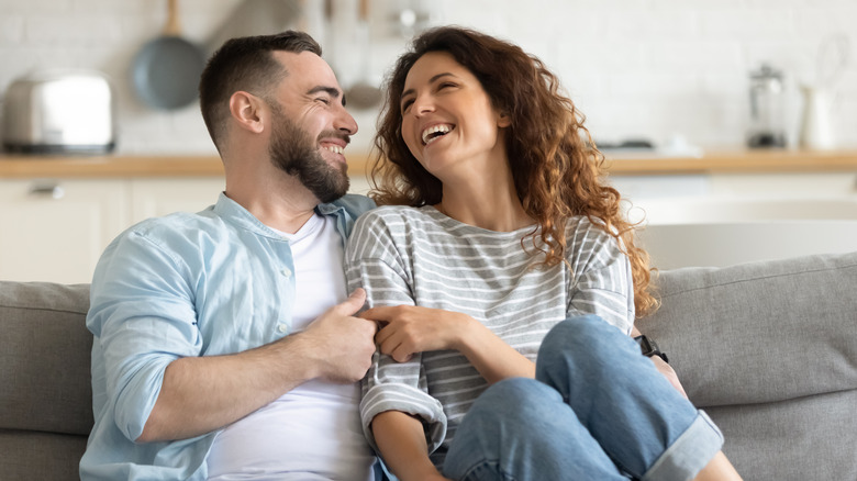 laughing man and woman hugging