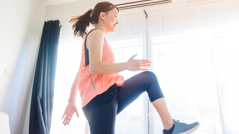 A woman does aerobic exercise at home