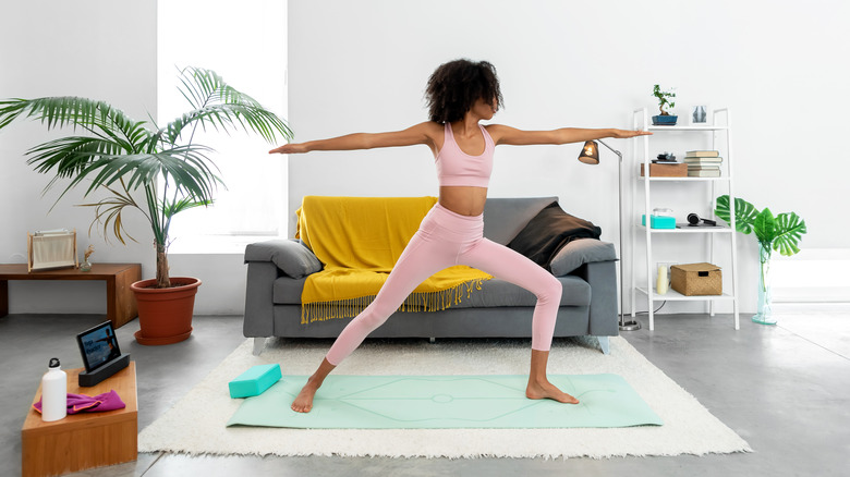 a woman practices yoga at home
