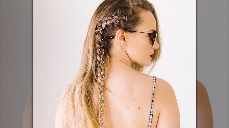 A woman with safety pins in her braid