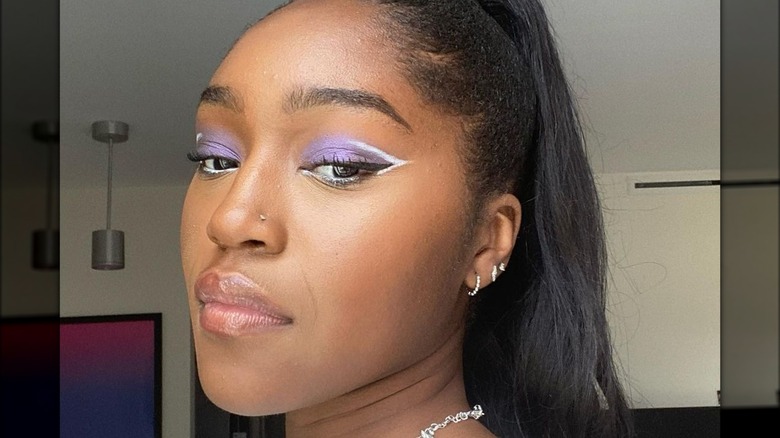 A woman with purple eye makeup