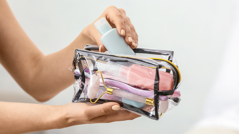 Woman holding clear makeup bag