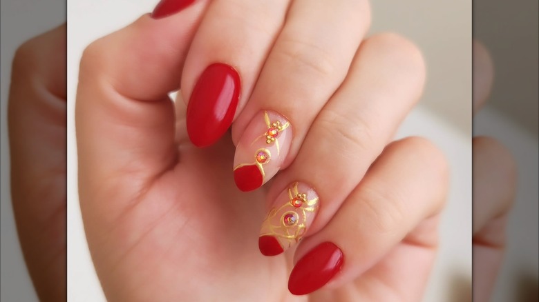 An art-deco manicure with red-and-gold nails