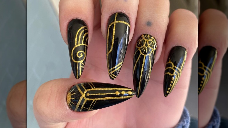 An art-deco manicure with black-and-gold nails