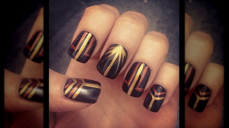 An art-deco manicure with black-and-gold nails