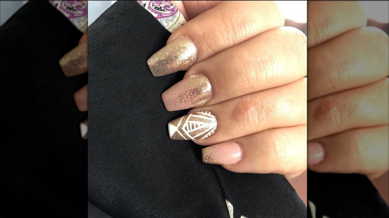 An art-deco manicure with white-and-gold nails