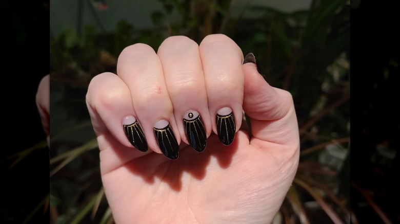 An art-deco manicure with black-and-gold nails