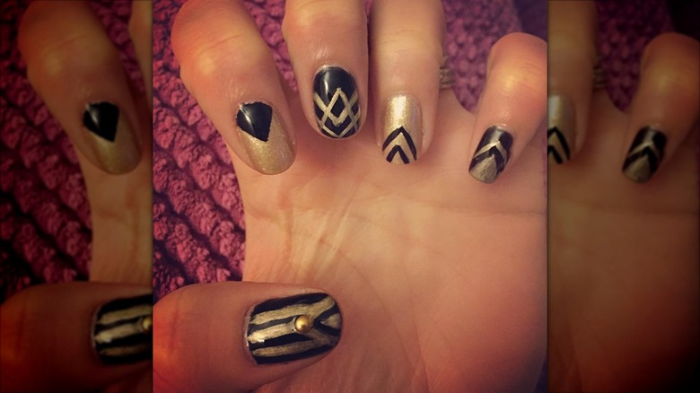 An art-deco manicure with black-and-gold nails