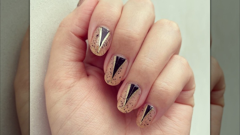 An art-deco manicure with black-and-gold nails