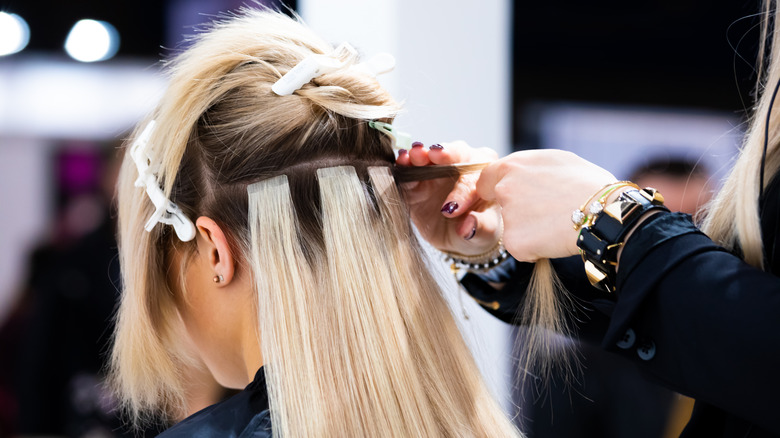 Woman getting hair extensions
