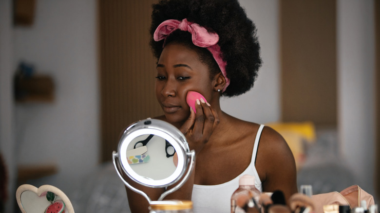 Woman applying foundation with a sponge