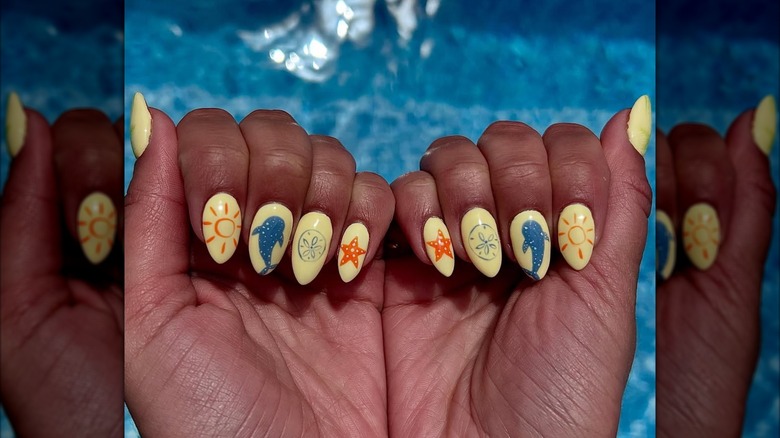 A pastel yellow beachy nail art design.