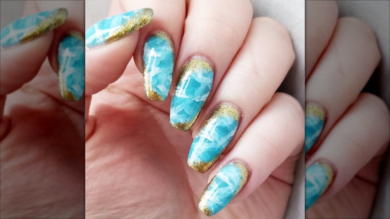 Aquamarine nails with godl detailing.
