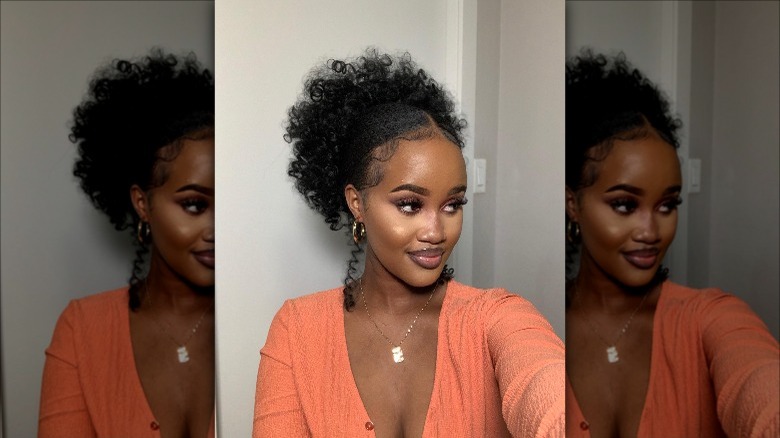 woman wearing high curly slicked back bun