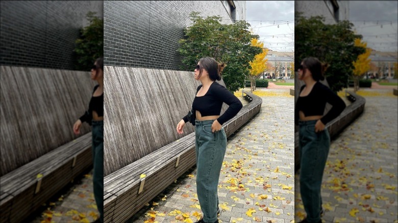 A woman wearing baggy jeans with a black long-sleeve top