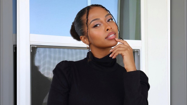 Low chignon style with face-framing braids