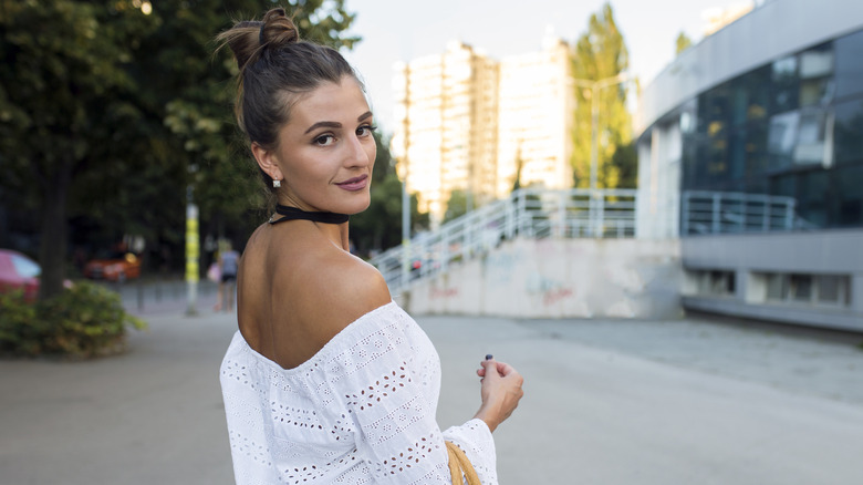 A woman wearing a choker and an off-the-shoulder top