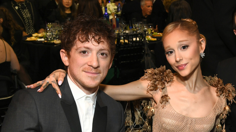 Ariana Grande places her arm around Ethan Slater