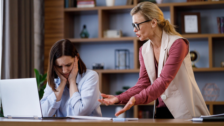 A woman scolding another woman while ignoring how uncomfortable she is