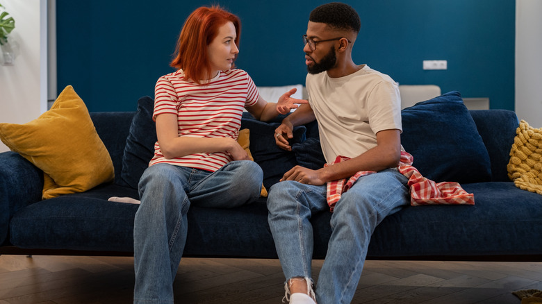 A couple arguing while sitting on a couch