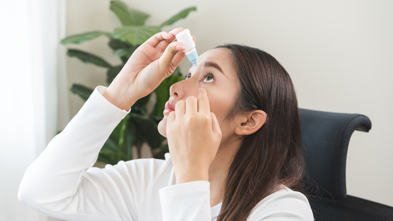 A woman using eye drops
