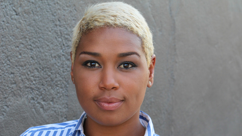 A woman with a blond pixie cut wearing a striped shirt