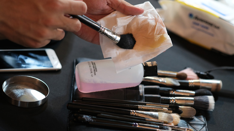 tapping makeup brush on towel