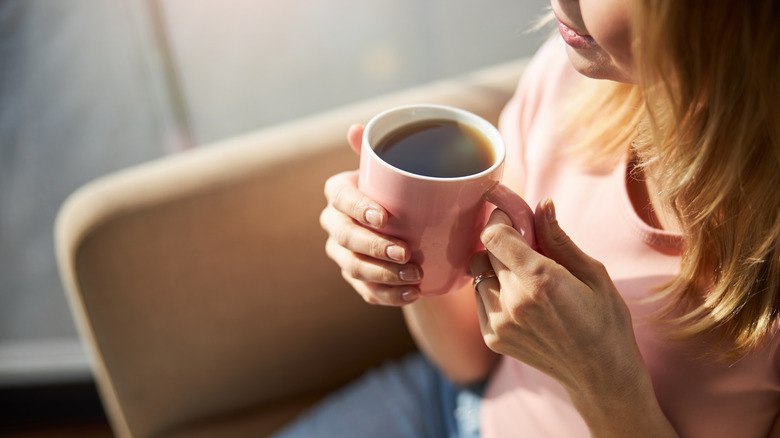 Woman holding pink coffee mug