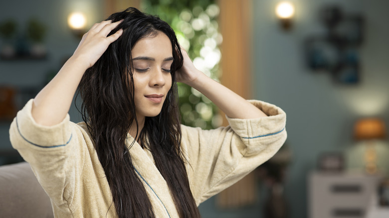 Woman massaging head with oil