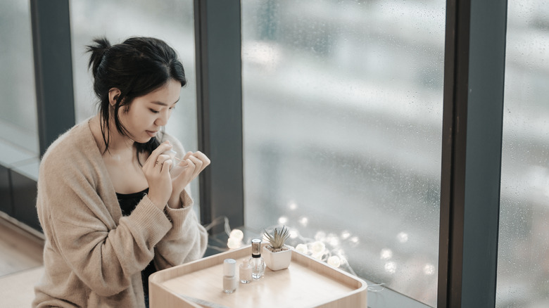 woman applying nail polish to a client